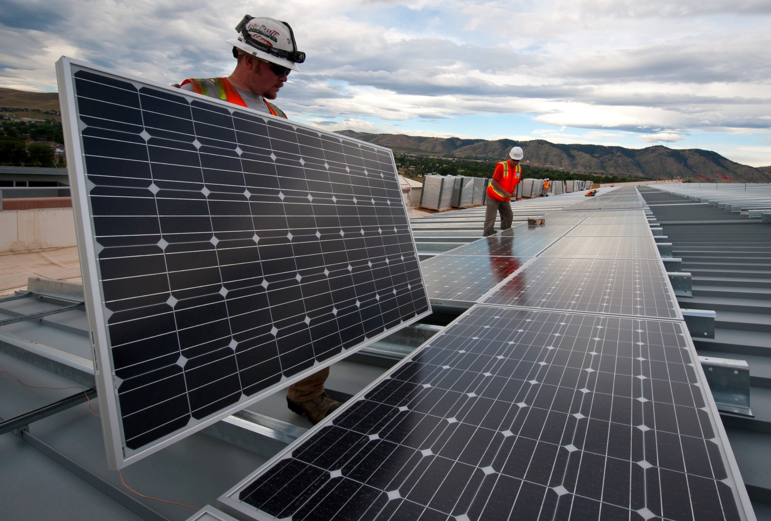 A team installing solar panels on a building rooftop